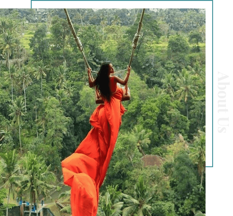 Woman in red dress swinging over tropical jungle