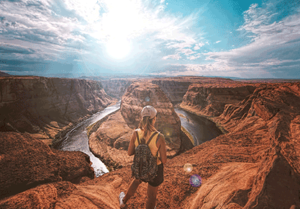 Hiker overlooking Horseshoe Bend canyon and river